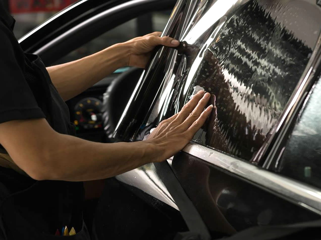 Especialista instalando un polarizado en un automóvil