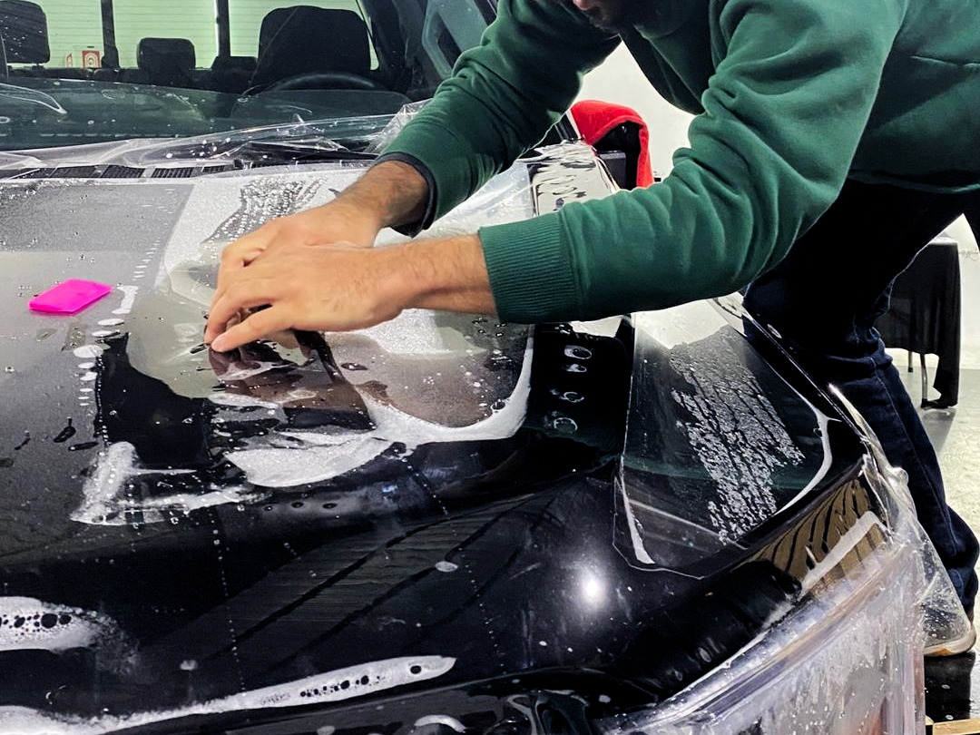 Especialista instalando un PPF en un automóvil
